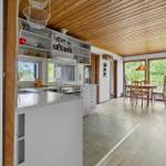 Küche mit Essbereich und Holzdecke. Tisch mit Stühlen und Fenster zur Aussicht.
