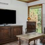 Ein Wohnzimmer mit Kamin, Fernseher und Holzmöbeln.