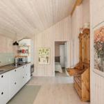 Küche mit Holzwand und Schlafzimmer im Hintergrund.