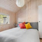 Schlafzimmer mit Holzwand, Bett und Fenster