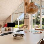 Moderne Wohnküche mit Blick auf den Garten. Esstisch, Sessel und TV sichtbar.