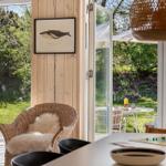 Wohnbereich mit Sitzgelegenheit und Blick auf Garten mit Feuerkorb.