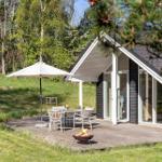 Haus mit Terrasse, Tisch, Stühlen, Sonnenschirm und Feuerkorb.