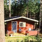 Rotes Holzhaus mit Veranda im Wald. Tür und Fenster sind sichtbar.