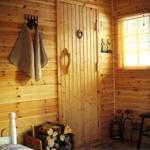 Holzvertäfelte Wand, Tür, Fenster mit Jalousie, Stuhl und Feuerholz