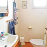 Badezimmer mit Waschbecken, Toilette und Fenster.