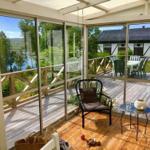 Terrasse mit Sitzgelegenheit und Blick auf See und Haus.