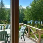 Terrasse mit Tisch und Stühlen, Blick auf Wald und Wasser