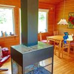 Holzvertäfelte Wohnung mit Kamin, Esstisch und Fenstern.