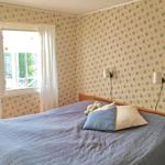 Schlafzimmer mit Bett, Fenster und Tapete mit Blumenmuster.