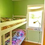 Zimmer mit Doppelstockbett, Fenster und Schreibtisch mit Lampe.