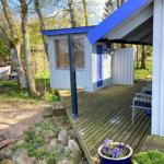 Holzterrasse mit blauem Pavillon und Boot auf Anhänger