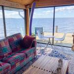 Wohnbereich mit Sofa, Tisch und Blick auf Wasser