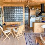 Holzvertäfelte Küche mit Essbereich und Glassteinwand