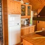 Küche mit Holzmöbeln, Spüle, Herd und Kühlschrank.