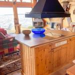 Küche mit Holzinsel, Blick auf Wasser, Sofa und Feuerkamin