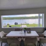 Esszimmer mit Tisch, Stühlen und Blick auf See