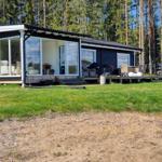 Schwarzes Haus mit Terrasse und Garten im Wald