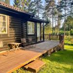 Holzhaus mit Terrasse, Stühlen und Tisch im Wald