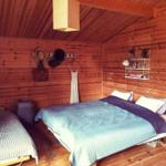 Schlafzimmer mit Holzwand, Bett und Kleiderhaken