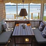 Sitzbereich mit Tisch und Fensterblick auf See