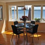 Esszimmer mit Tisch, Stühlen und Aussicht auf See