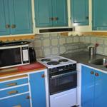 Küche mit blauen Schränken, Herd und Spüle.