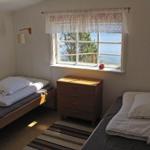 Zwei Betten, Schrank und Fenster mit Meerblick.