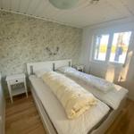 Schlafzimmer mit Doppelbett, Tapete und Fenster.