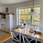 Esszimmer mit Tisch, Stühlen und Blick auf Wald