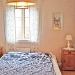 Schlafzimmer mit Bett, zwei Nachttischen und Fenster mit Vorhängen.