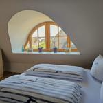 Schlafzimmer mit Dachschräge, Fenster und Bett