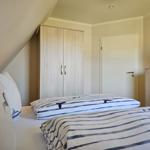 Schlafzimmer mit Doppelbett, Kleiderschrank und Tür