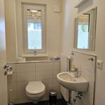 Badezimmer mit Toilette, Waschbecken und Fenster