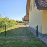 Hinterhof mit Gartenzaun und Tor. Gelber Hauswand und Dachreep.