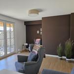 Wohnzimmer mit Sitzgelegenheiten, Pflanzen und Blick auf die Terrasse.