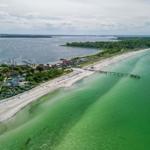 Strand mit Bootshafen und grünem Wasser. Ferienhaus in der Nähe.