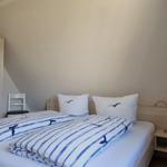 Schlafzimmer mit Doppelbett, Nachttisch und Kleiderschrank unter schrägem Dach