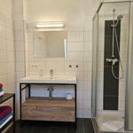 Badezimmer mit Dusche, Waschbecken und Handtüchern.