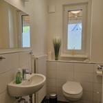 Badezimmer mit Waschbecken, Toilette und Fenster