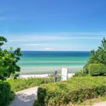 Weg führt zur Strandpromenade mit Blick auf das Meer und den Strand.