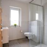 Badezimmer mit Dusche, Toilette und Waschbecken.