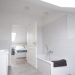 Badezimmer mit Badewanne und Blick in das Schlafzimmer