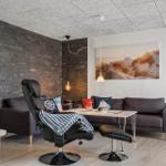 Wohnzimmer mit Sofa, Sessel und Wandbild