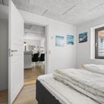 Schlafzimmer mit Blick in Wohnbereich und Fenster mit Blick auf Außenbereich.