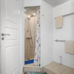 Badezimmer mit Dusche, Handtuchhalter und Tür.