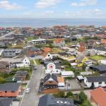 Luftbild einer Küstenstadt mit vielen Häusern und Blick auf das Meer.