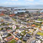Luftbild von Nidde Sange mit Häusern, Straßen und Hafenansicht.