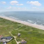 Strand mit Dünen und Häusern in der Ferne