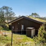 Holzhaus mit grüner Dachbegrünung, Außentisch und Stühle im Gras.